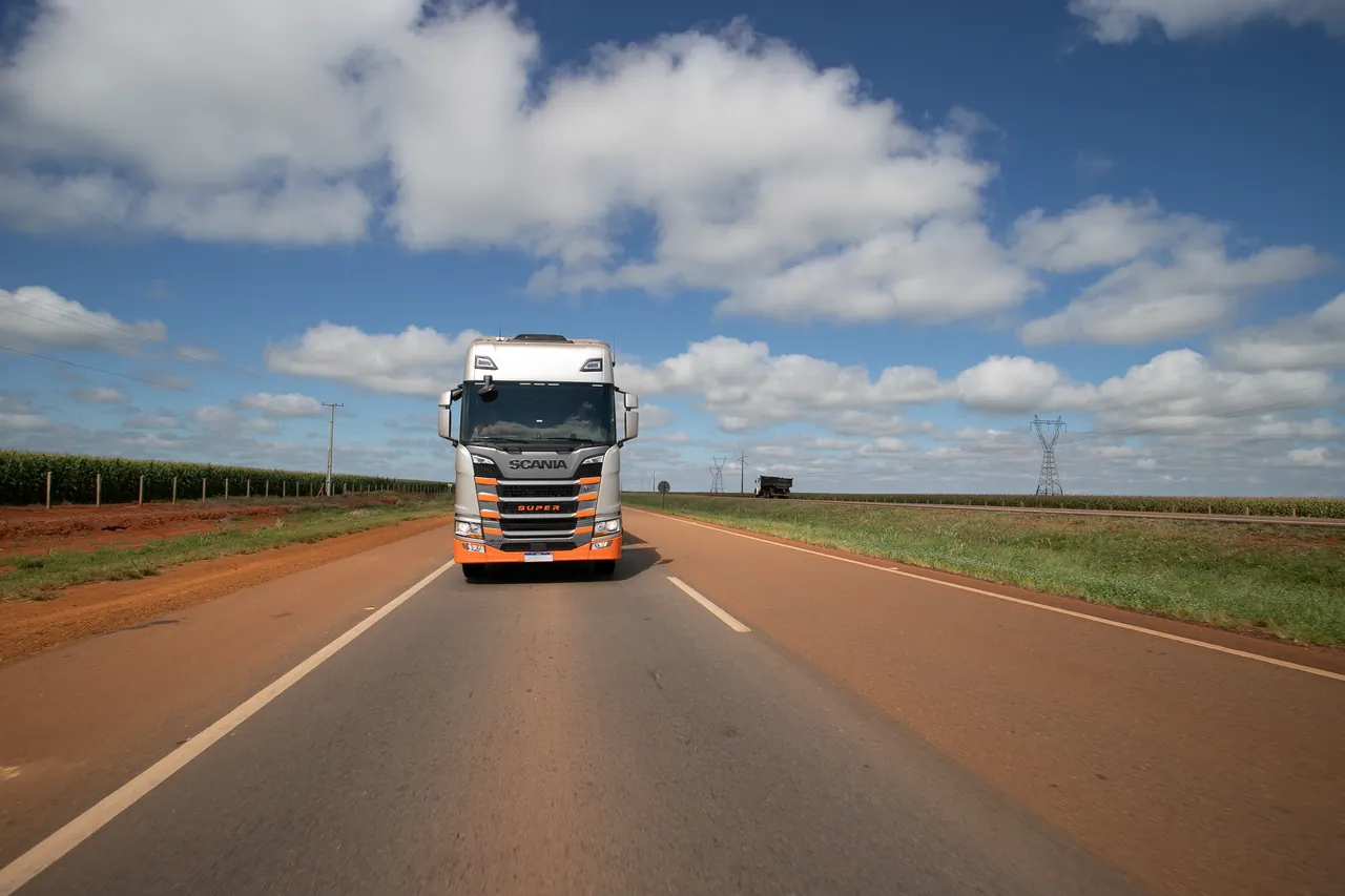 Caminhão em rodovia sob céu aberto.