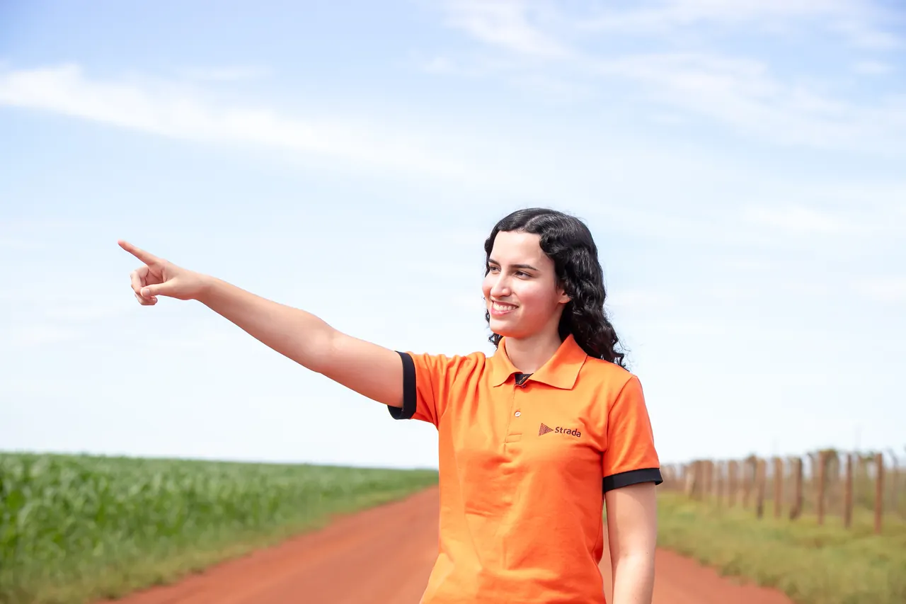 Colaboradora da Strada apontando para o horizonte.
