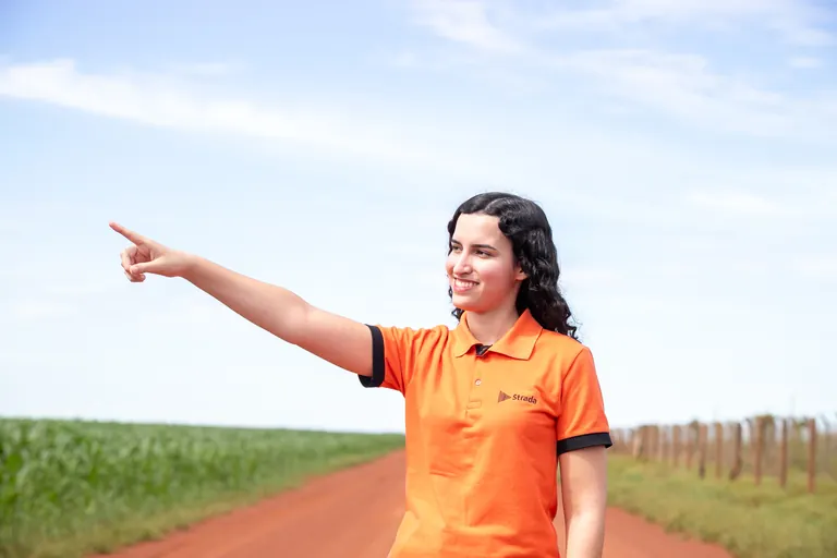 Colaboradora da Strada apontando para o horizonte.